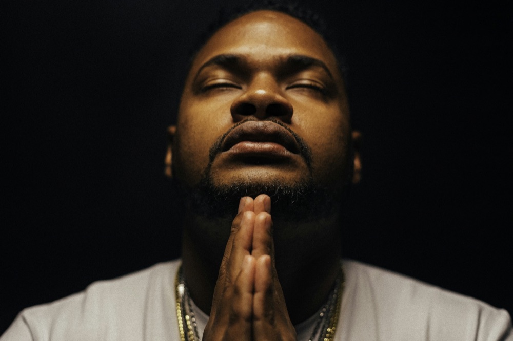 A man praying with his eyes closed and hands folded